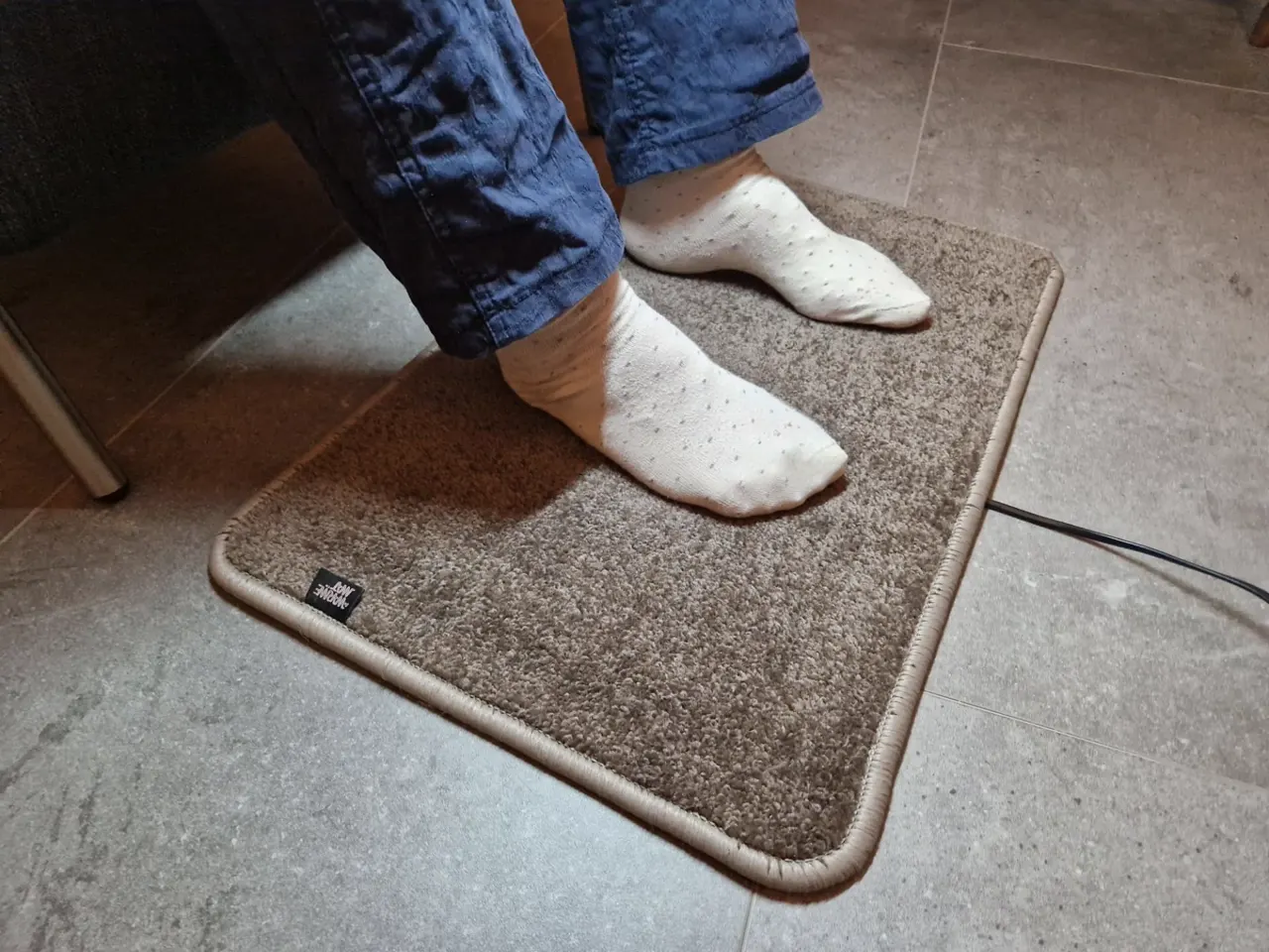 Taupe verwarmde voetenmat van opzij: dikke hoogpolige voetenmat met verwarming